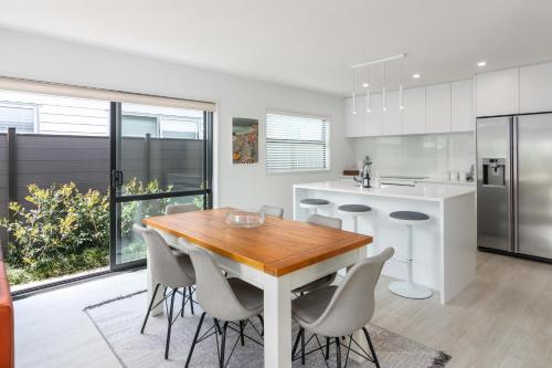 a kitchen with a wooden table and chairs at Coastal Delight - close to the Beach and shops in Papamoa