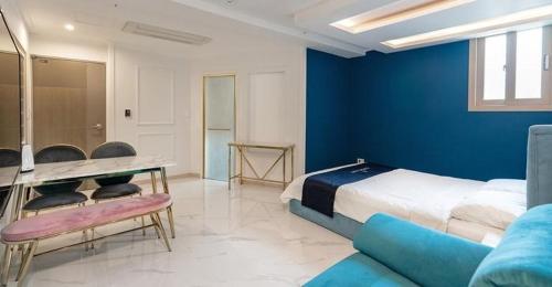 The Bay Hotel and Pool Villa في سون تشون: غرفة نوم بسرير وجدار ازرق