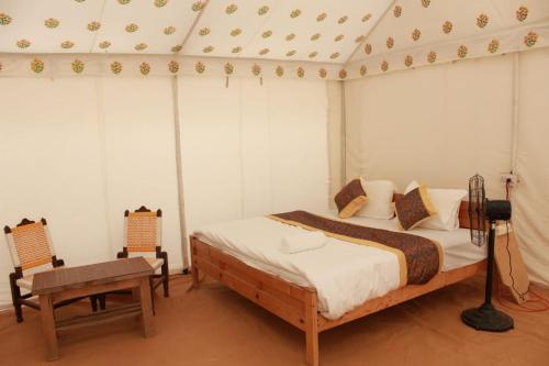 Un dormitorio con una cama y una mesa. en Hindustan Desert Camp en Kūri