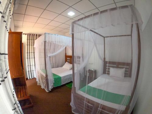 a room with two beds in a tent at Wilpattu Mookalan Resort in Habawewa