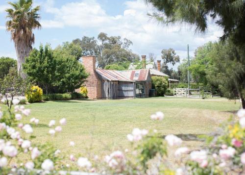an old brick house in a field with trees at The Bower Mudgee in Mudgee