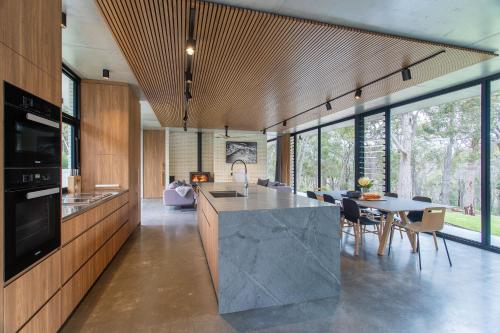 a kitchen with a large island and a table with chairs at Boomerang House I Private Properties in Quindalup