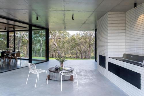 a room with two chairs and a table on a patio at Boomerang House I Private Properties in Quindalup