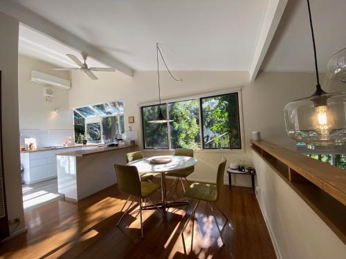 cocina y comedor con mesa y sillas en Sassafras Treehouse Private home in the Dandenong Ranges, Victoria, en Sassafras