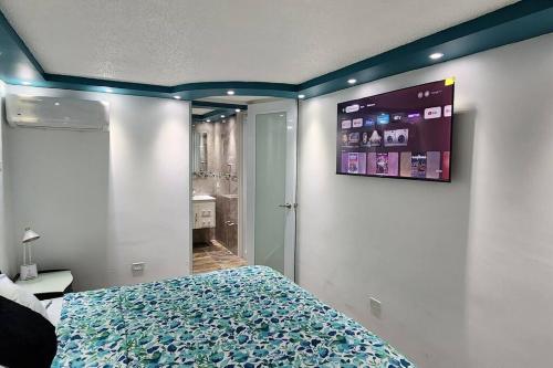 a bedroom with a bed and a tv on the wall at RH los angeles (#2) 2do floor front of airport in Sabana Abajo