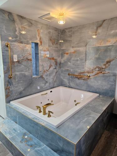 a bathroom with a large tub with blue tiles at Travelodge Inn & Suites by Wyndham Fullerton in Fullerton