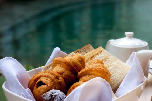 a basket of pastries and bread on a table at Anumana Village Ubud in Ubud