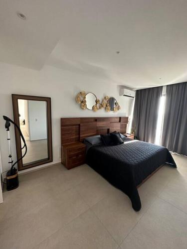 a bedroom with a large bed and a mirror at Paraíso frente al Mar 816 in Nuevo Vallarta