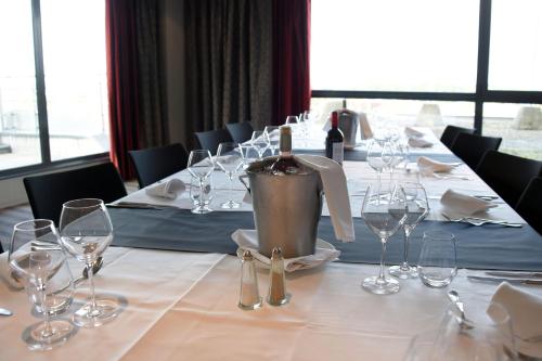 a long table with wine glasses on it at Holiday Inn Mulhouse by IHG in Mulhouse