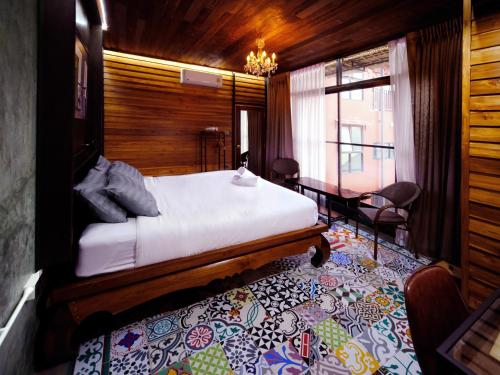 曼谷的住宿－Photohostel，木制客房内的一间卧室,配有一张床