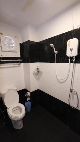 a bathroom with a toilet and a shower in it at Kings Auto Guesthouse in Hua Hin