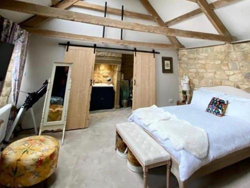 a bedroom with a bed and a stone wall at Bird In Bush Elsdon in Elsdon