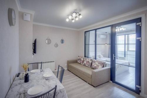 a living room with a couch and a table with a dining room at Asaapart Ush-Sunkar 153 in Almaty