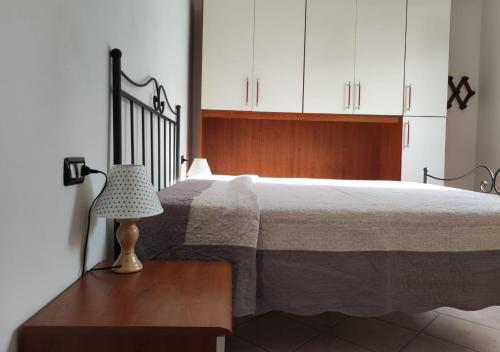 1 dormitorio con 1 cama y 1 lámpara en una mesa en Casa del Sole en Riotorto