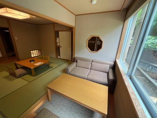 a room with a couch and a table and a window at Jozankei Daiichi Hotel Suizantei in Jozankei