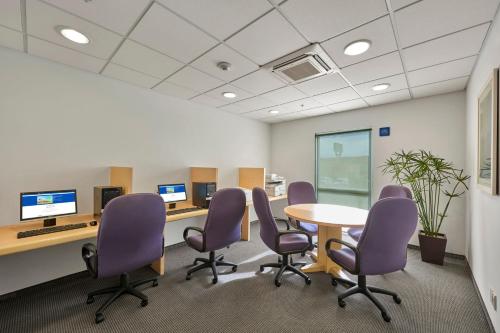 a conference room with purple chairs and a table and computer monitors at City Express by Marriott Nogales in Nogales