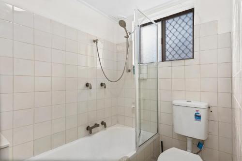 een badkamer met een douche en een toilet bij Pepe's Beach Pad in Towradgi