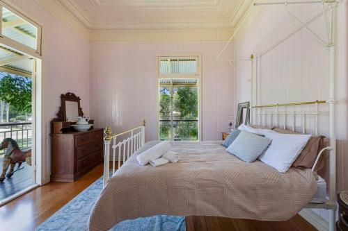 a bedroom with a large bed and a window at A Charming Queenslander in Bundaberg
