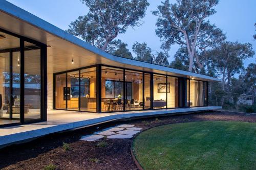 a house with large glass windows and a lawn at Boomerang House I Private Properties in Quindalup