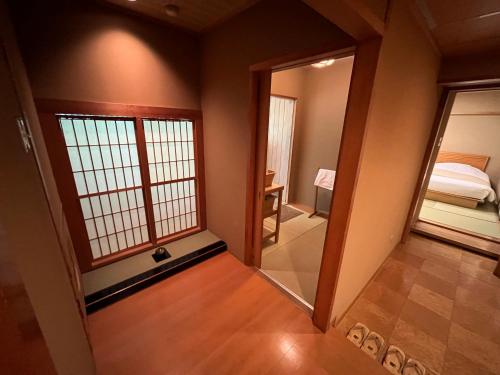 a room with a door and a bedroom with a bed at Jozankei Daiichi Hotel Suizantei in Jozankei