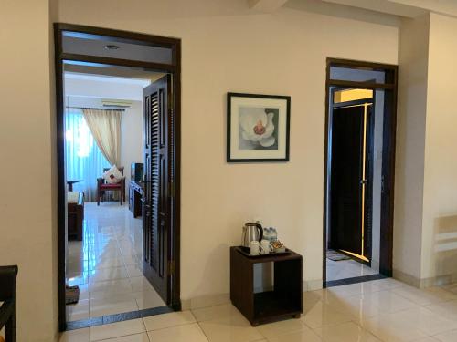 a hallway with two open doors and a living room at Nirwana Suites in Denpasar