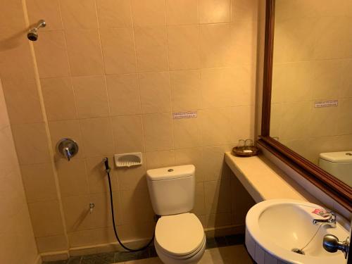 a bathroom with a toilet and a sink at Nirwana Suites in Denpasar