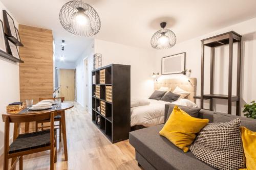 a living room with a bed and a couch and a table at Maior 5 Apartamentos in Verín