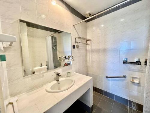 une salle de bain blanche avec un lavabo et un miroir dans l'établissement Mahkota Prd Pahlawan Homestay 1Rom-4pax/free wi-fi, à Malacca