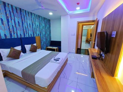 a bedroom with a large bed and a television at HOTEL ROCK in Anand