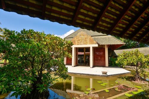 a small building in the middle of a garden at The Palms in Bentota