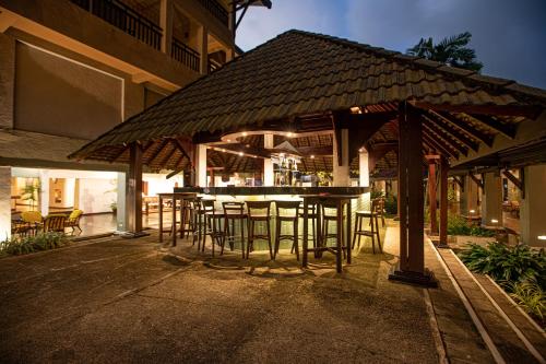 an outdoor bar with chairs and tables in front of a building at The Palms in Bentota