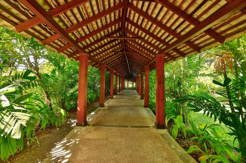 a wooden covered walkway with a wooden pergola at The Palms in Bentota