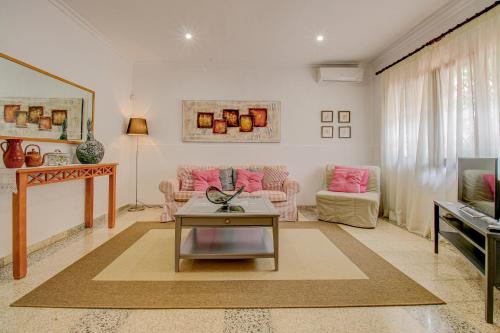 a living room with pink furniture and a table at Finca Can Tiro in Costitx