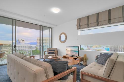 uma sala de estar com um sofá e uma televisão em The Reef Pad, ideally located with a stellar view! em Cairns