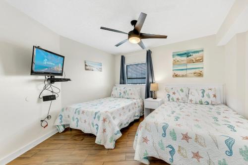 1 dormitorio con 2 camas y ventilador de techo en Seaside Beach & Racquet 5614, en Romar Beach