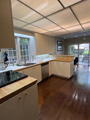 a large kitchen with white cabinets and wooden floors at 49 Hostel in Toronto