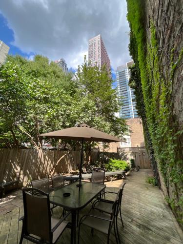 une table et des chaises avec un parasol sur une terrasse dans l'établissement 49 Hostel, à Toronto