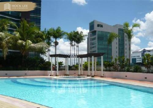 una gran piscina con palmeras y edificios en Hock Lee Hotel & Residences, en Kuching