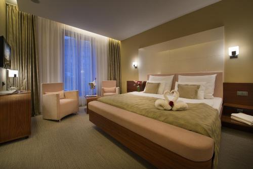 a hotel room with a bed with a stuffed animal on it at Wellness Hotel Diamant in Hluboká nad Vltavou