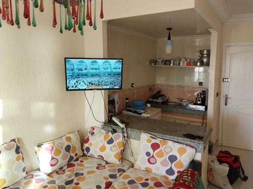 ein Wohnzimmer mit einem Sofa und einem Flachbild-TV in der Unterkunft Piso vistas al mar in Asilah