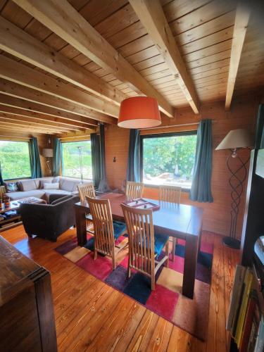 uma sala de estar com mesa e cadeiras em Le chalet du Cerf - Chambres d'hôtes em Somme-Leuze