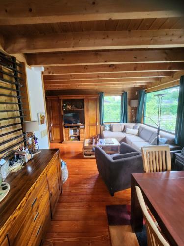a living room with a couch and a table at Le chalet du Cerf - Chambre d'hôte in Somme-Leuze