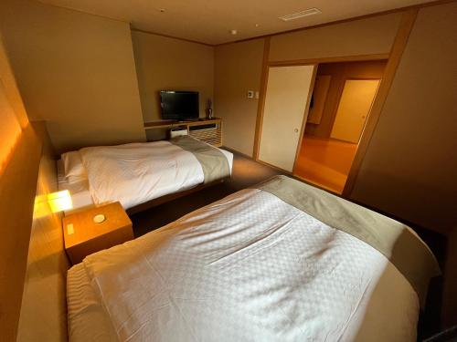 a hotel room with two beds and a television at Jozankei Daiichi Hotel Suizantei in Jozankei
