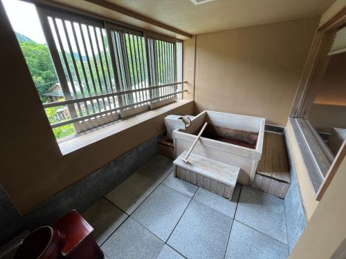a room with a balcony with a sink and a window at Jozankei Daiichi Hotel Suizantei in Jozankei
