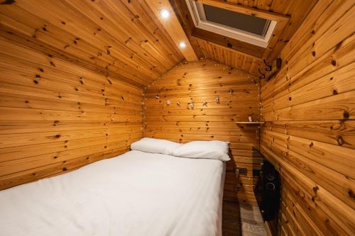 a bedroom with a bed in a wooden room at Delny Glamping and Farm Animals in Invergordon
