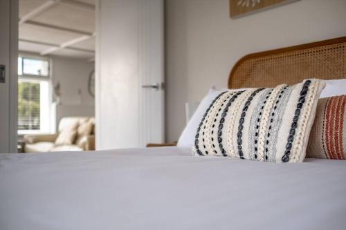 a bed with two pillows on top of it at Elusive Penguin in Bicheno