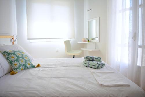 a white bedroom with a bed and a chair at Tarmaros - Families & Groups in Sissi