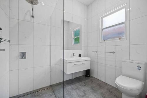 een witte badkamer met een toilet en een wastafel bij Soldiers on Brougham in Ballarat