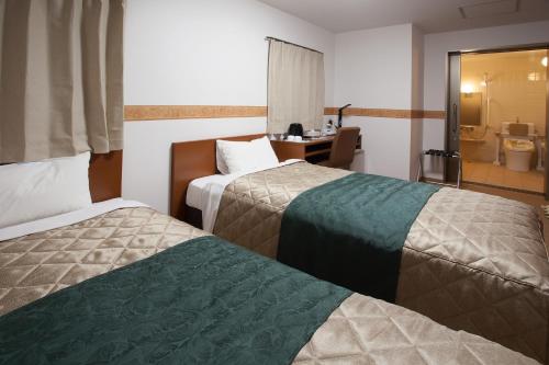 a hotel room with two beds and a bathroom at レックスインなんば in Osaka
