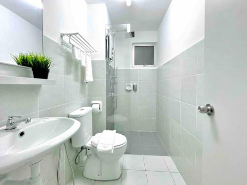 La salle de bains blanche est pourvue de toilettes et d'un lavabo. dans l'établissement Studio Room Alanis Suite @ KLIA, à Sepang
